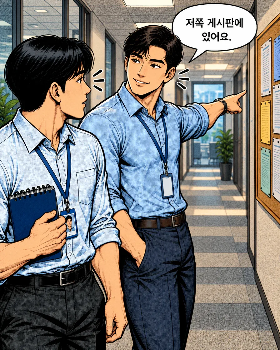 동료가 게시판을 가리키며 신입사원에게 안내문 위치를 알려준다.